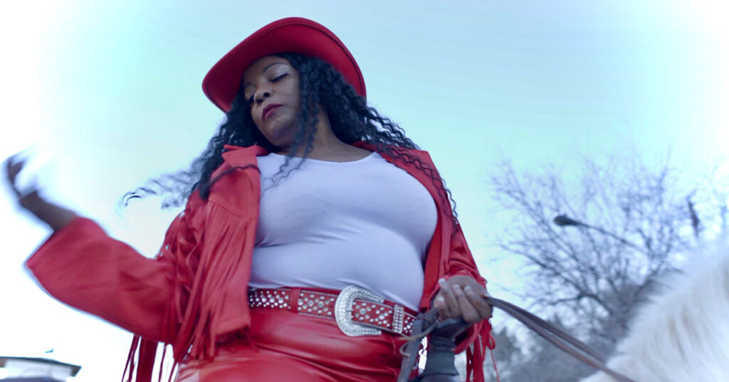Yahinus cowgirl looking over shoulder riding a horse